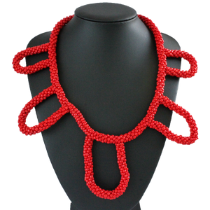 African handmade necklace with red beads on black display